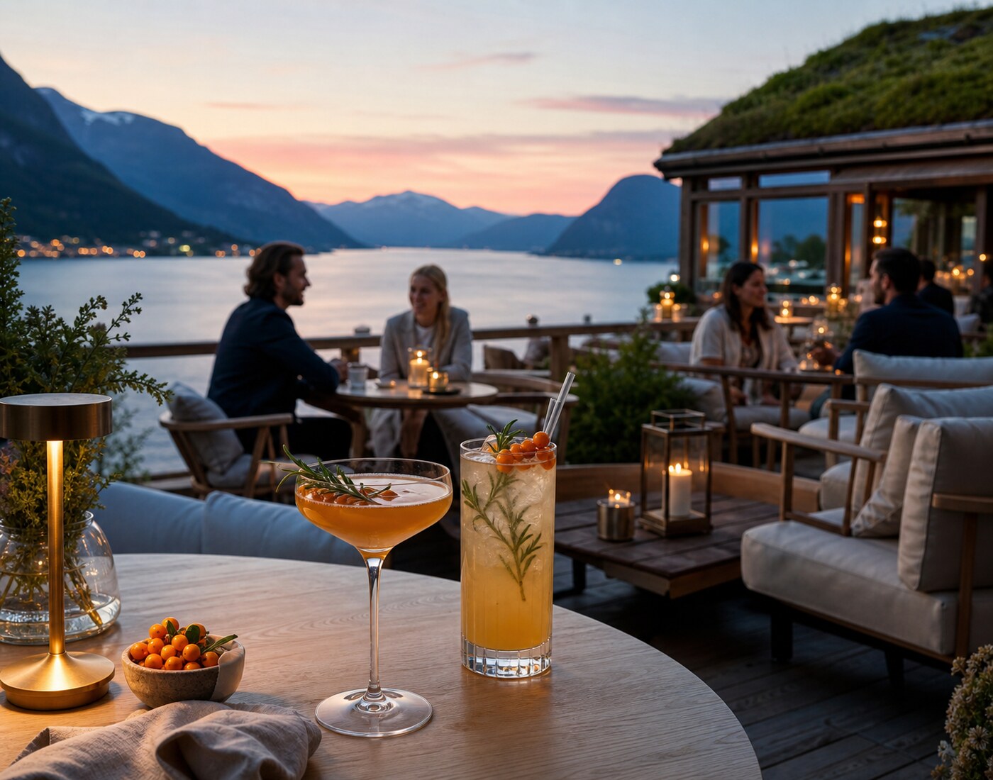 Opplyst fjordterrasse med elegante cocktails etter solnedgang